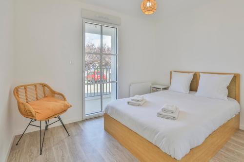 Un dormitorio con una cama y una silla y una ventana. en Appartement neuf à 5 minutes à pied de la plage, en Barbâtre