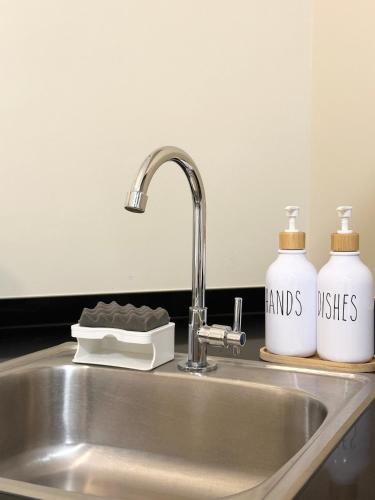 a kitchen sink with two bottles of hand sanitizers at Condo in Cagayan de Oro City in Cagayan de Oro