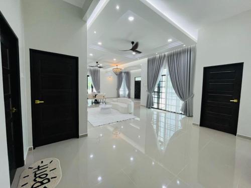 a large white room with black doors and a living room at Husna WhiteStay in Bukit Payong
