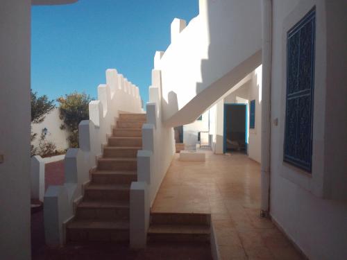 a stairway leading to a building with white walls and a stair case at taguermess 2 in Midoun