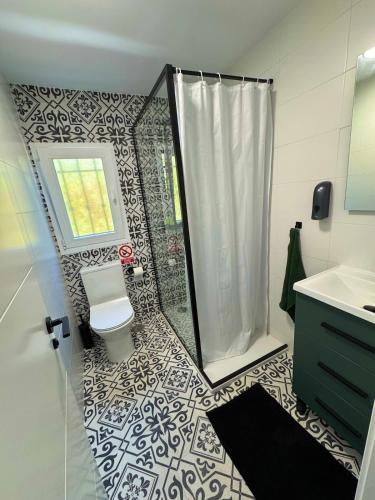 a bathroom with a shower with a toilet and a sink at Las Colinas in Illana