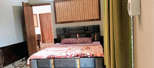 a bedroom with a bed with a black head board at Anha Farmstay in Mādho Tānda