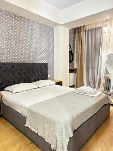 une chambre avec un grand lit avec une tête de lit noire dans l'établissement Helihome Apartment Tbilisi, à Tbilissi