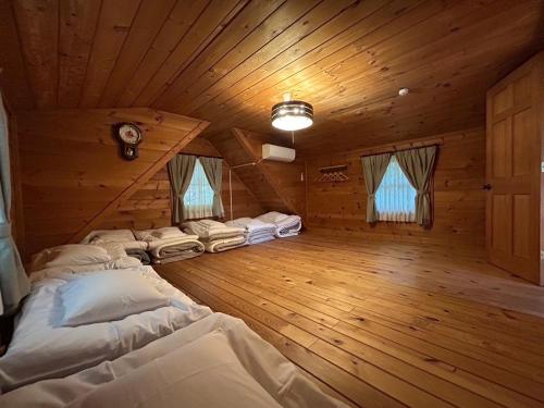 a bedroom in a log cabin with beds in it at 松川湖の目の前に佇む貸切ログハウス ファミーユ松川湖 in Ito