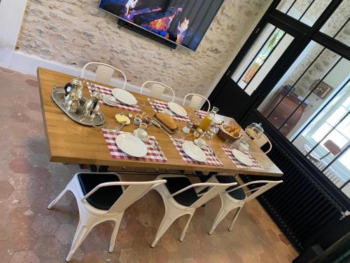 ein Holztisch mit Tellern voller Essen darauf in der Unterkunft Loft dans le clocher face au chateau in Bonnelles