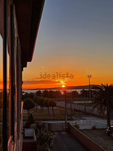 Una puesta de sol sobre un estacionamiento con la puesta del sol en A Lanzada Con Amor, en Sanxenxo