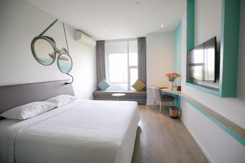 a bedroom with a white bed and a mirror at Liberty Hotel Saigon Parkview in Ho Chi Minh City