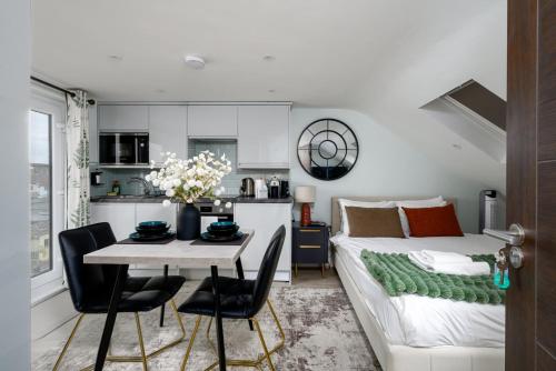 a living room with a bed and a table and chairs at Greenford Apartments in Perivale