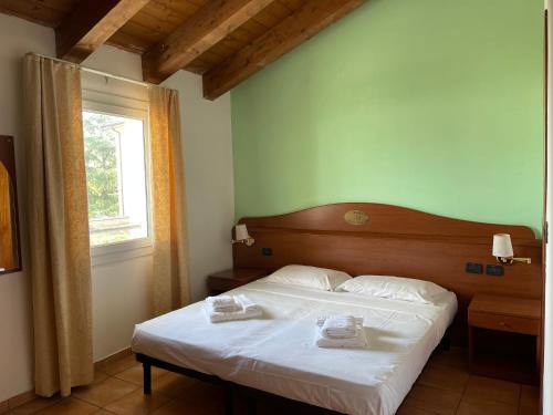 a bedroom with a bed with two towels on it at Hotel Conte Luna in Bologna