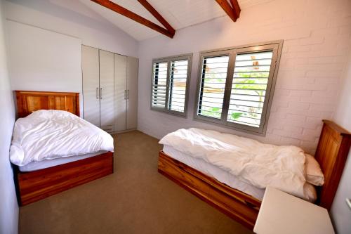 Un dormitorio con dos camas y dos ventanas. en bobinga peksan, en Sedgefield