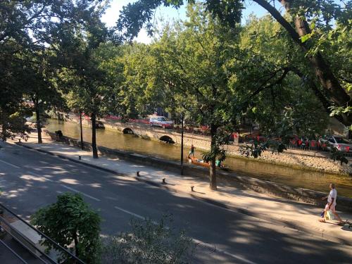 a group of people walking on a sidewalk next to a river at Chez Anna- Centre-ville - Petit-déjeuner in LʼIsle-sur-la-Sorgue