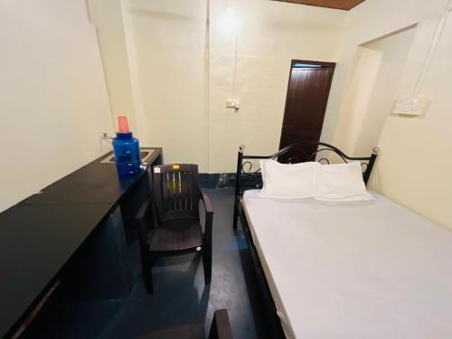 a small room with a bed and a chair at Siilver Sands Hutt Homestay - Malpe Beach in Malpe