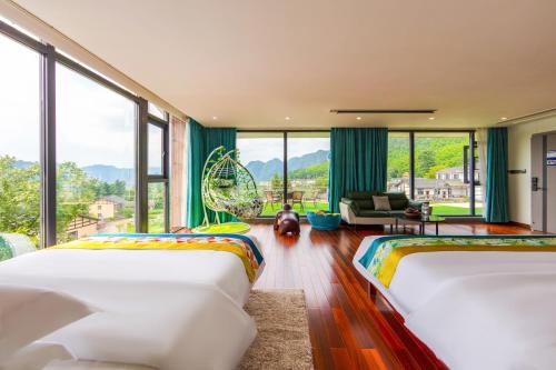 two beds in a room with large windows at Zhangjiajie Cloudscape Lodge-English Services-Near the Ticket Gate in Zhangjiajie