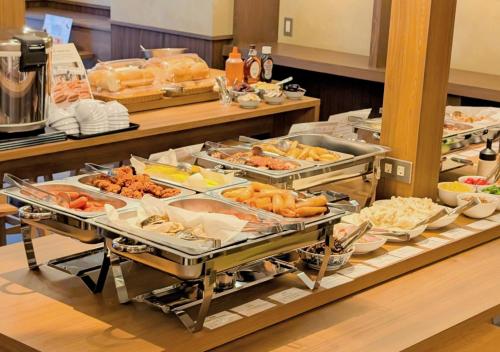 Una línea de buffet con muchos tipos diferentes de comida. en APA Hotel Morioka Ekimae, en Morioka