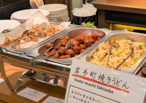 un buffet di cibo con polpette e pasta su un tavolo di APA Hotel Morioka Ekimae a Morioka