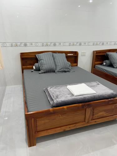 a wooden bed sitting in a room with at Nhà Nghỉ NHẬT TIÊN in Tân Phú