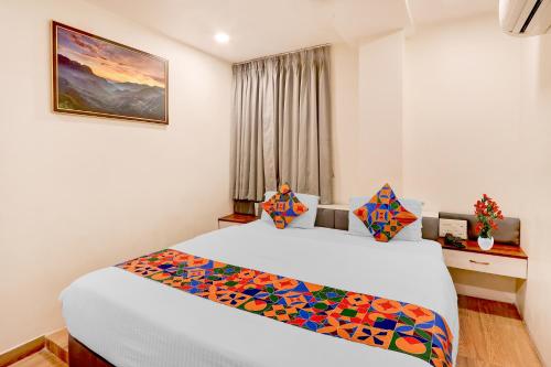 a hotel room with a bed and a window at FabHotel Radha Rani Residency in Khammam