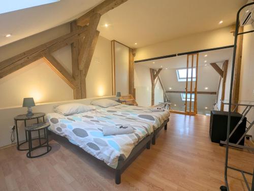 ein Schlafzimmer mit einem großen Bett in einem Zimmer in der Unterkunft Duplex dans grande ferme rénovée in Divonne-les-Bains