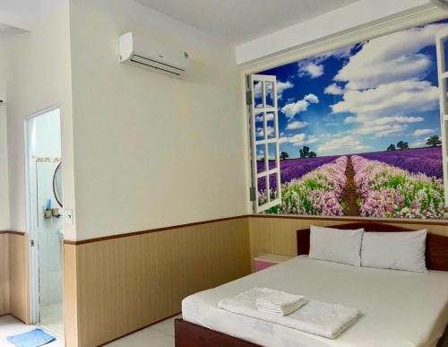 una camera da letto con una finestra con un campo di fiori di Nhà Nghỉ Kim Phượng Vũng Tàu a Vung Tau
