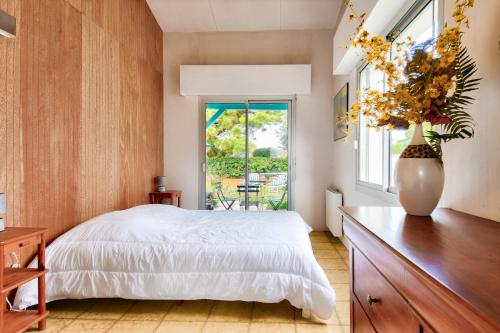 a bedroom with a large bed and a window at 700m de la plage, jardin, 4 adultes 2 enfants in Le Fier