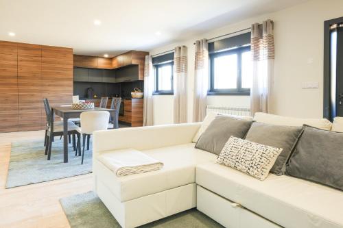 a living room with a white couch and a dining room at Chalés Avelino Carolino ll com Roteiro incluído in Chaves