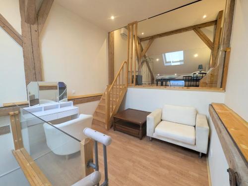 ein Wohnzimmer mit einer Treppe und einem Spiegel in der Unterkunft Duplex dans grande ferme rénovée in Divonne-les-Bains