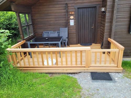a porch of a cabin with a table and a table at Ferienhaus Nr 10, Typ A, Feriendorf Jägerpark, Bayerischer Wald in Prackenbach