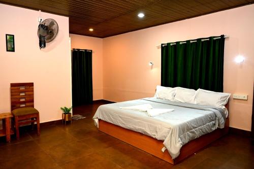 a bedroom with a bed with a green curtain at Zayana Gardens Family Private Room in Anachal