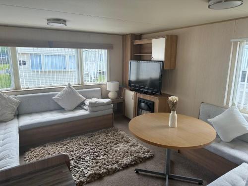 a living room with a couch and a table at Caravan by the Sea 641 in Kinmel Bay