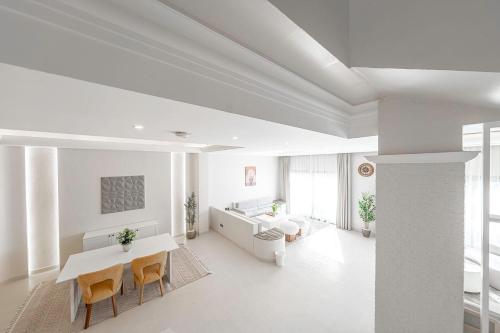 a white living room with a table and chairs at Mabaat-Jasmine Greek Villa 4BR- 583 Villa 5 in Jeddah