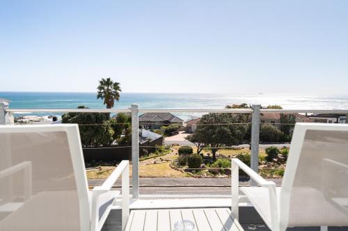 a balcony with two chairs and a view of the ocean at Finchley Guesthouse in Camps Bay in Cape Town