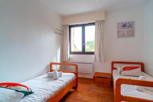a bedroom with two beds and a window at Ciel Etoilé - Proche de la mer in Locmariaquer