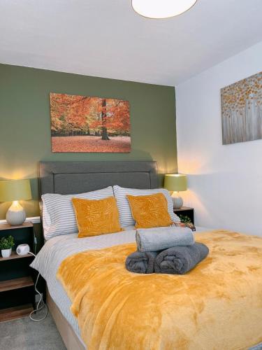 a bedroom with a large bed with orange pillows at Modern 3-bed house with parking - Chorley Near M61 in Heapey