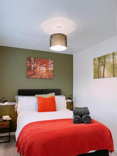 a bedroom with a bed with a red blanket at Modern 3-bed house with parking - Chorley Near M61 in Heapey
