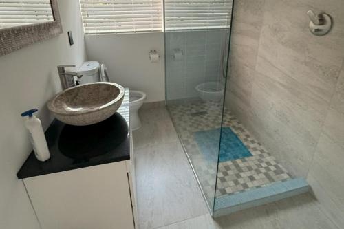 ein Badezimmer mit Waschbecken und Glasdusche in der Unterkunft Cottage - Sleeps 4 - Pet friendly - Pool - Parking in Johannesburg