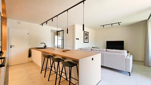 a kitchen and living room with a bar and a couch at Appartement Porte Bonheur in Rochefort