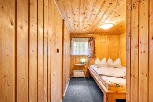 una camera da letto con un letto in una cabina di legno di Bungalow 12 - Finnhütte a Quitzdorf