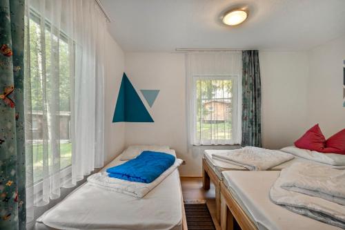 una stanza con tre letti e una finestra di Bungalow 15 - Finnhütte a Quitzdorf