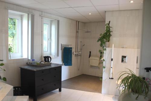 a bathroom with a shower and a sink and a refrigerator at B&B Even Heukelom - Kamer met Tuin in Afferden