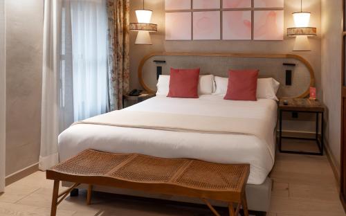ムンカーダにあるTradere Hotel Boutiqueの大きな白いベッドと赤い枕のある寝室