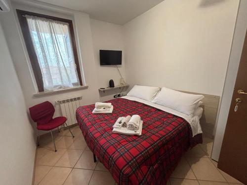 ein Schlafzimmer mit einem Bett mit zwei Paar Schuhen darauf in der Unterkunft B&B Canossa in Rodigo
