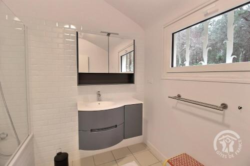 a bathroom with a sink and a mirror at La maison de la plage à 6 in Trégastel