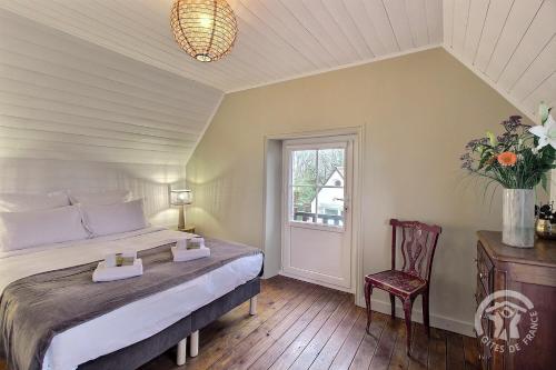 a bedroom with a bed and a chair and a window at La maison de la plage à 6 in Trégastel