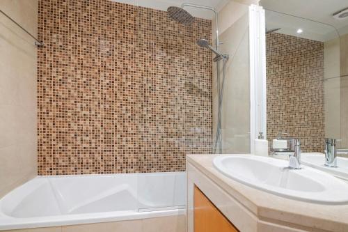 a bathroom with a white tub and a sink at Do Vale Hollidays in Galé