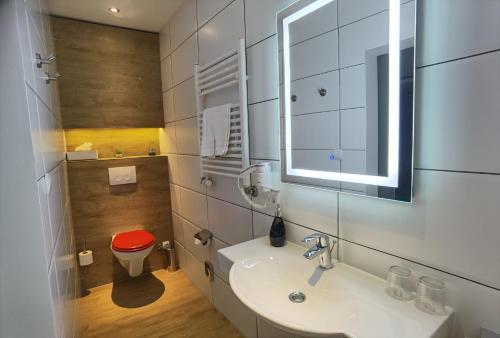 a bathroom with a sink and a red stool at Das Waldhaus - Winter Boardinghaus in Forbach