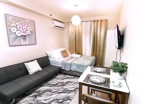 a small living room with a couch and a bed at Condo in Lapu-Lapu near airport w free parking in Agus
