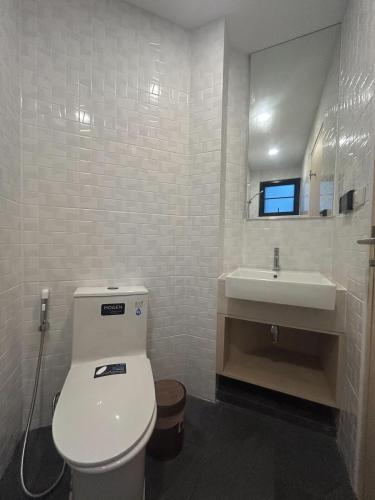 a bathroom with a white toilet and a sink at K5 Seaview Hillside 3BR and 1 Staff Quarter in Ban Ko Kok