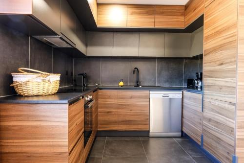 a kitchen with wooden cabinets and a white dishwasher at Chalés Avelino Carolino l com Roteiro incluído in Chaves