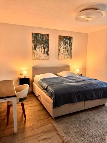 - une chambre avec un lit, un bureau et deux peintures dans l'établissement Perviz, à Braunau am Inn