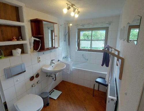 Un baño con lavabo, bañera e inodoro. en Ferienwohnung 19 Gipfelblick, en Schwangau